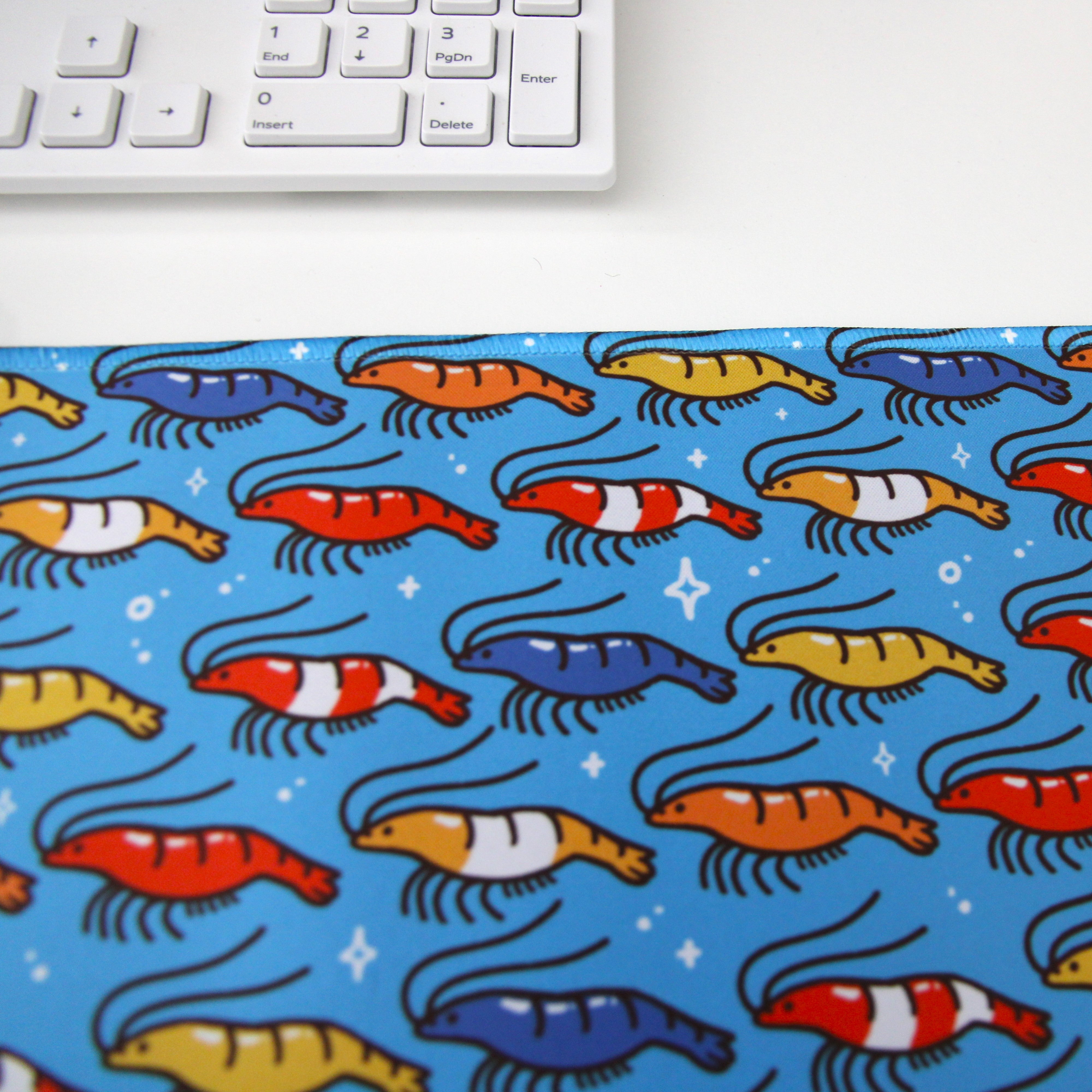 Bright blue desk mat patterned with shrimp