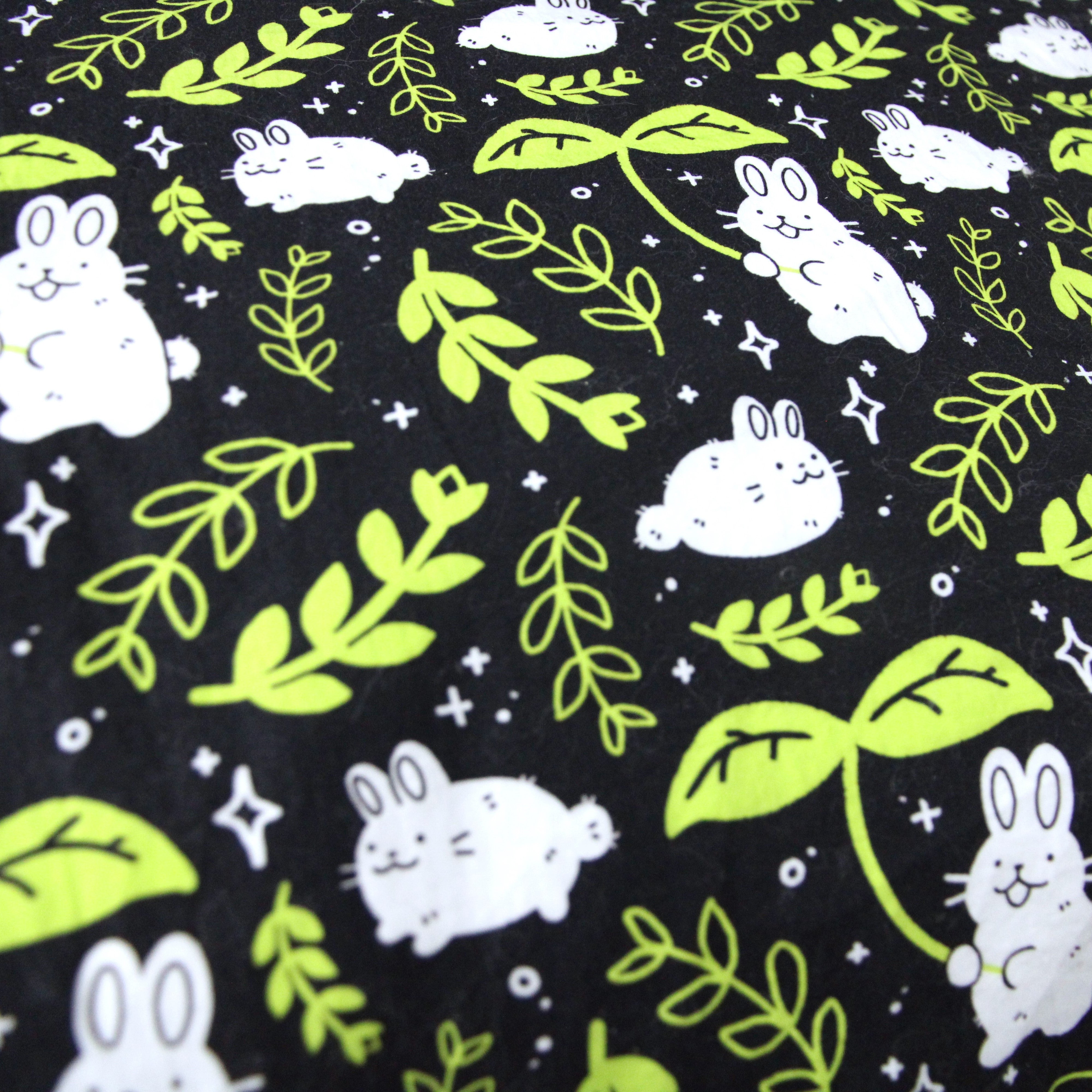 Black pillow case patterned with rabbits and yellow green leaves