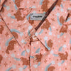 Salmon pink button up shirt patterned with brown dogs and blue shooting stars