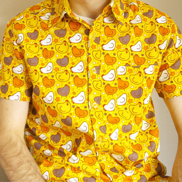 yellow button up shirt patterned with chickens and stars, worn by a model