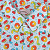 Light blue button up shirt patterned with various gummy candies including red and blue gummy worms, yellow and green gummy worms, peach rings, cherries, and watermelon slices. Between the candies are blue sparkles and a faint wavy grid background.