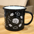 Black enamel mug with white interior. Printed design in white ink: sleeping dog drawn in a cute style, surrounded by a circle of sheep, stars, and sparkles