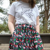 Black skirt with pockets patterned with cats and cherries. Midi skirt below knee length