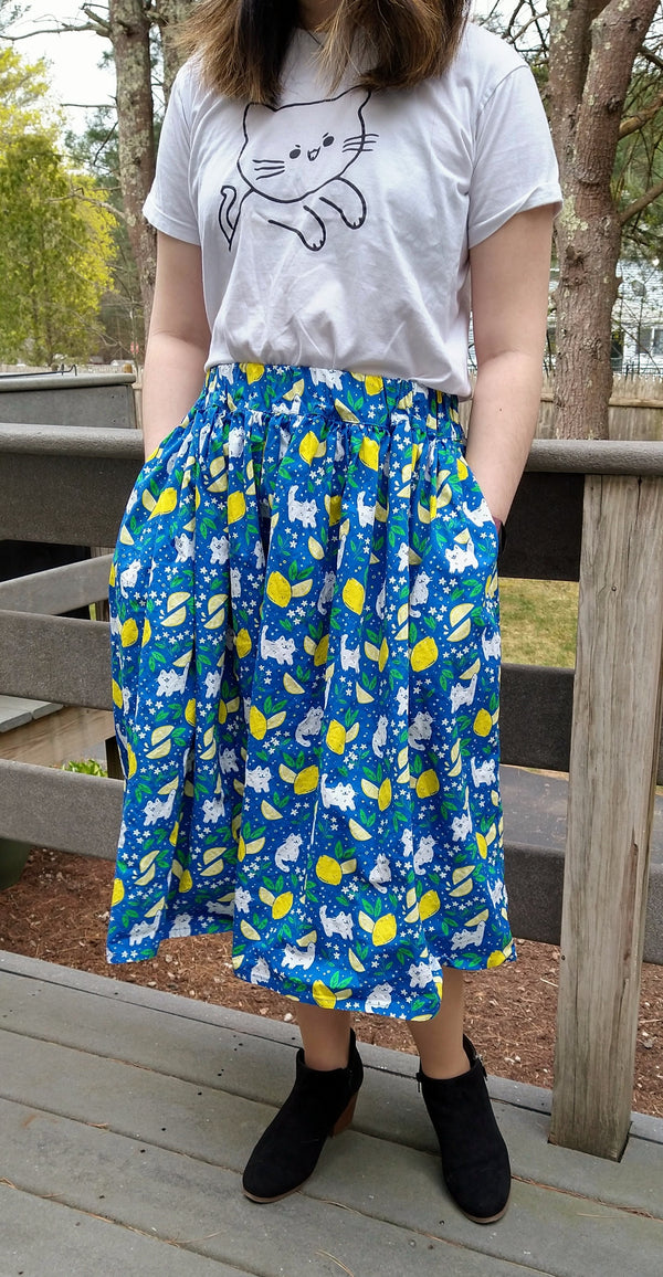 Blue skirt with pockets patterned with cats and lemons