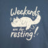 Blue shirt printed with white ink graphic of a cat lying down with its eyes closed. Text reads "Weekends are for resting!"