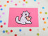 postcard mini print of a cat eating a slice of strawberry shortcake with crumbs on the side of its mouth, drawn in a kawaii style