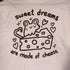 cream colored tee with graphic of a mouse with a block of swiss cheese. the mouse's tail is curled in the shape of a heart. text reads "sweet dreams are made of cheese"