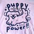 pink graphic tee printed with cute drawing of a dog with a shiny nose surrounded by flowers and stars. text reads "puppy power!!"