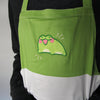 Color block apron with green, white, and black cotton. Embroidered with happy frog