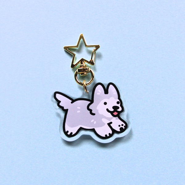 Clear acrylic charm. Grey husky or gray husky keychain with golden star shaped clasp on a light blue background