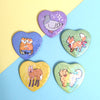 5 heart-shaped pinback buttons featuring pigeon, red fox, dog, maned wolf, and tigers, all holographic