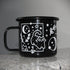 Black enamel mug with black rim. Cats, moon, plants, and stars printed in white ink. Black cat camping mug