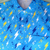 Sky blue button up shirt patterned with lightning bolts and sparkles. The color scheme is blue, yellow, and white.