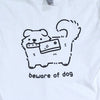 White t shirt printed with black ink graphic of a cute fluffy dog holding a knife (meat cleaver) in its mouth. Text reads "beware of dog"