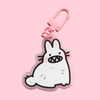 Keychain of a cute bunny baring sharp teeth. The keychain has a pink clasp
